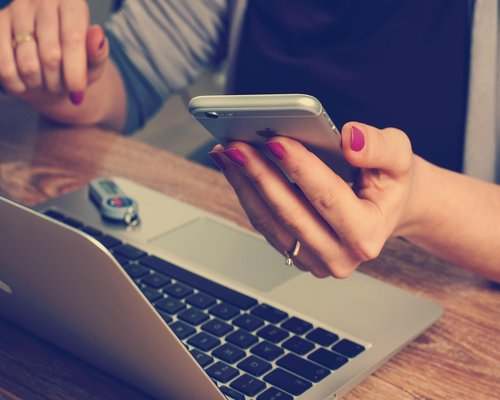 Phone notebook and water on a work desk